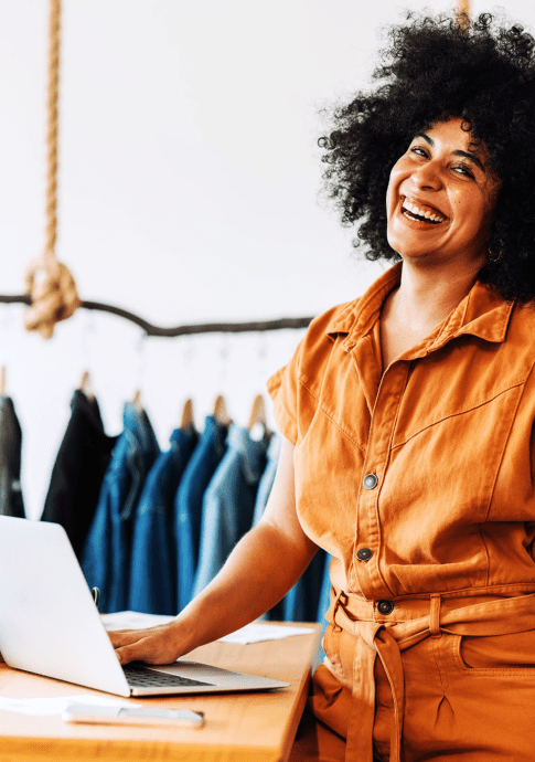 Woman business owner of clothing store on laptop.