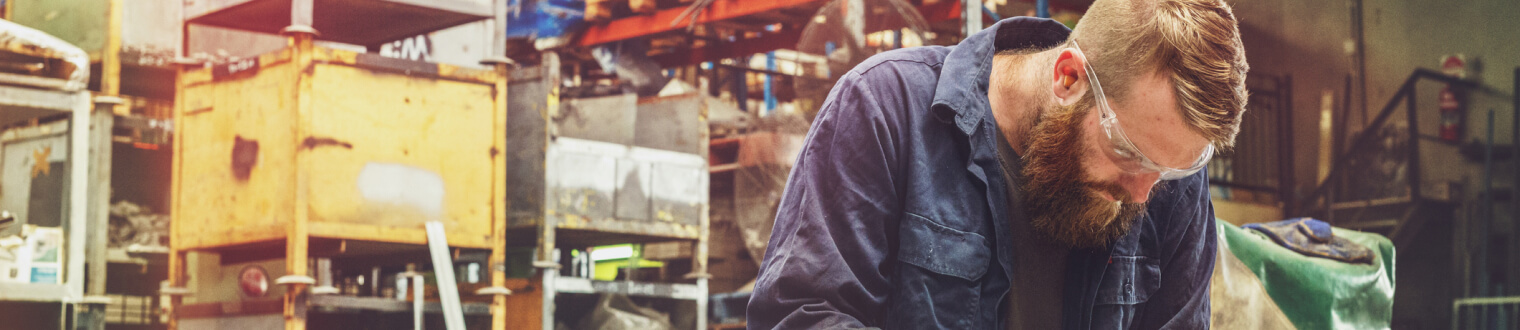 blue-collar worker in safety glasses in a warehouse